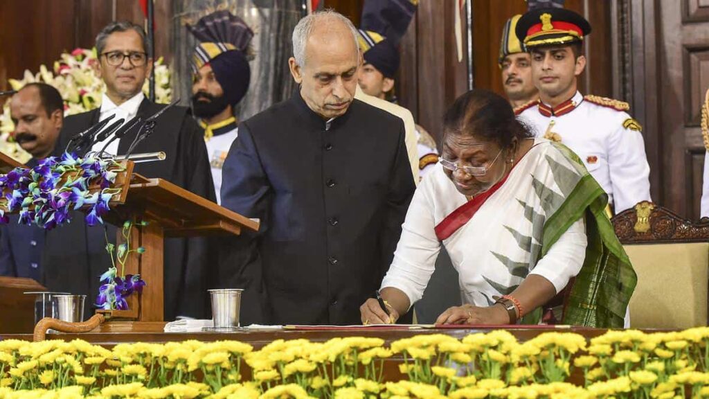 India’s 15th President Droupadi Murmu signs a register after taking oath in the Central Hall of Parliament, in New Delhi, Monday, July 25, 2022. | Photo Credit: PTI